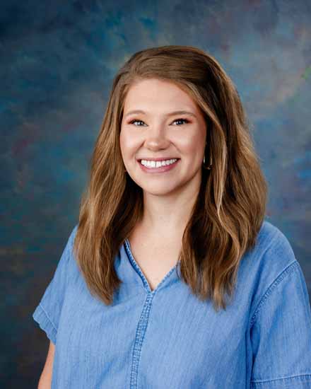 Brooklyn Fuhrwerk smiling in a headshot, wearing a blue denim shirt.