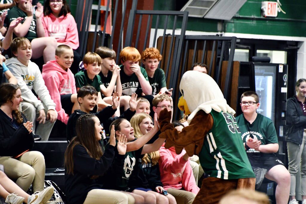 Middle School Pep Rally Eagle high fives students in the audience